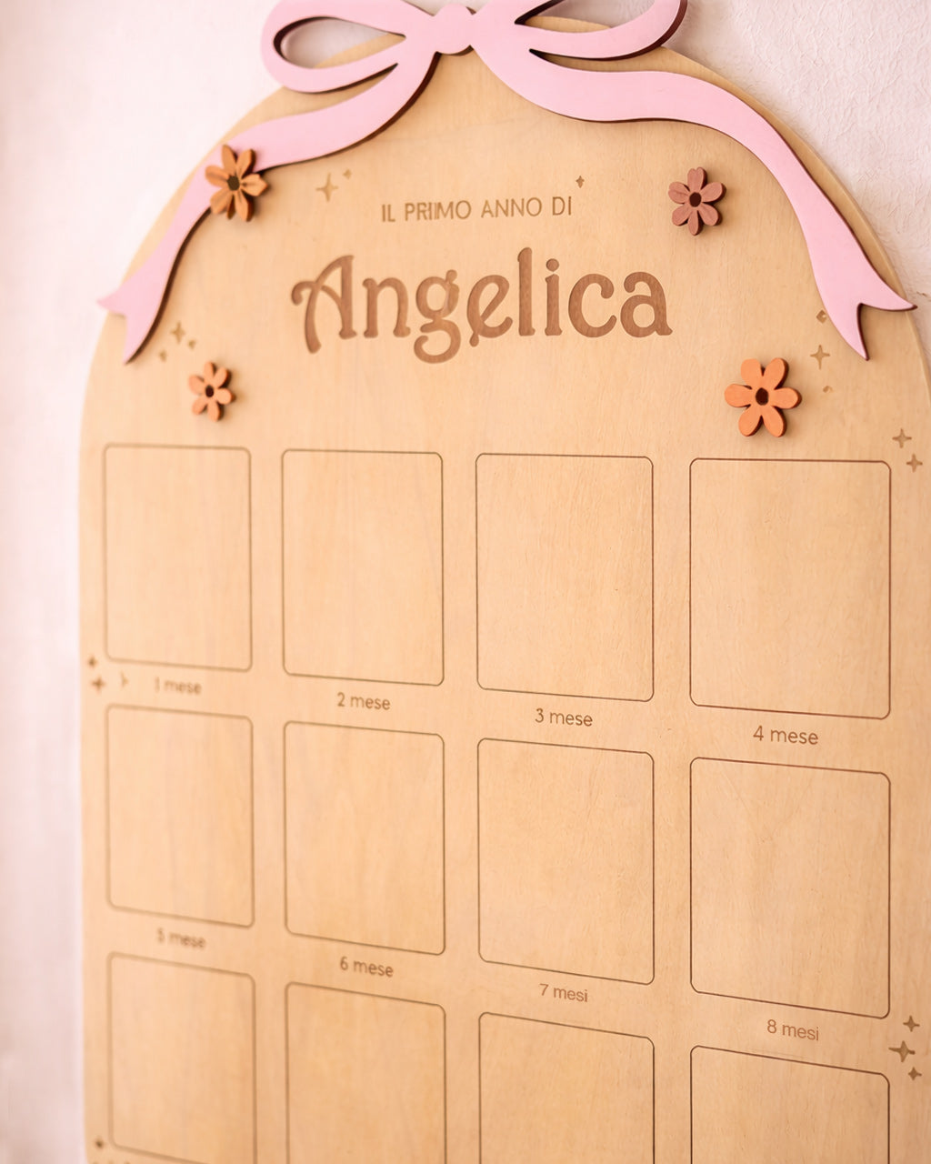 Dettaglio bacheca primo anno bambina in legno — fiocco rosa, fiorellini colorati e nome inciso laser