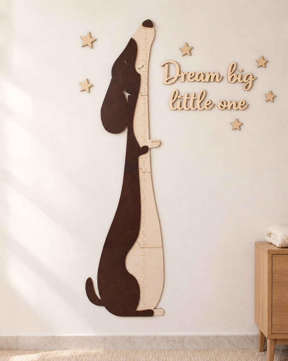 Metro crescita Otto Bassotto in legno appeso alla parete di una cameretta, accanto alla scritta in legno Dream big little one venduta a parte