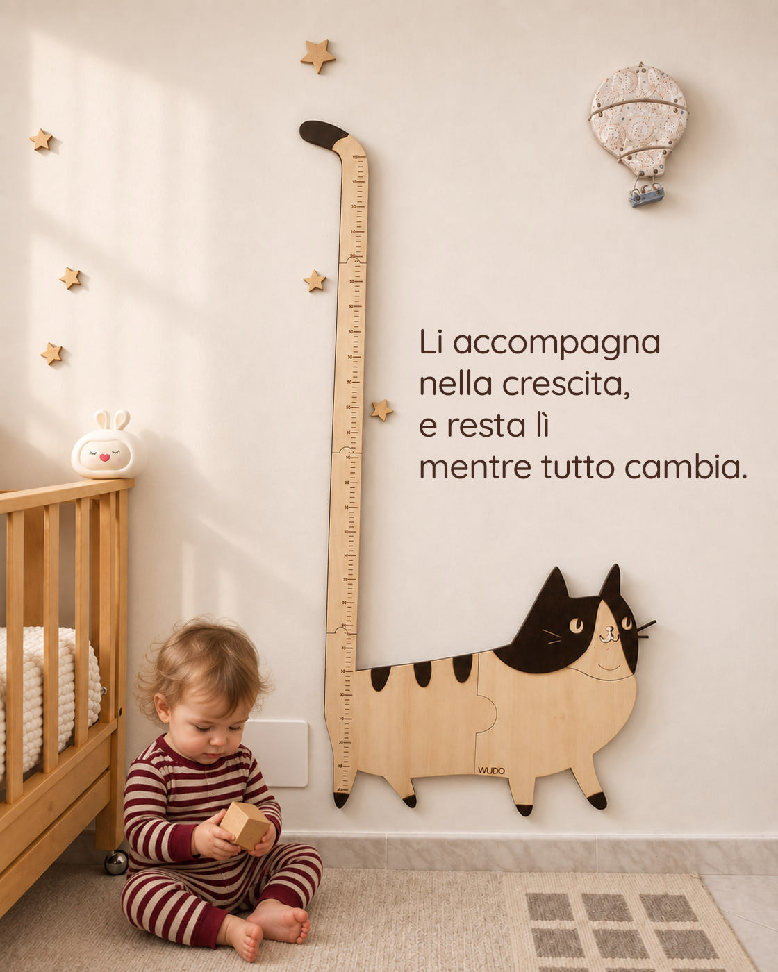 Bimbo seduto gioca con un cubo di legno accanto al metro crescita Bettina la Gattina, con la scritta: Li accompagna nella crescita, e resta lì mentre tutto cambia