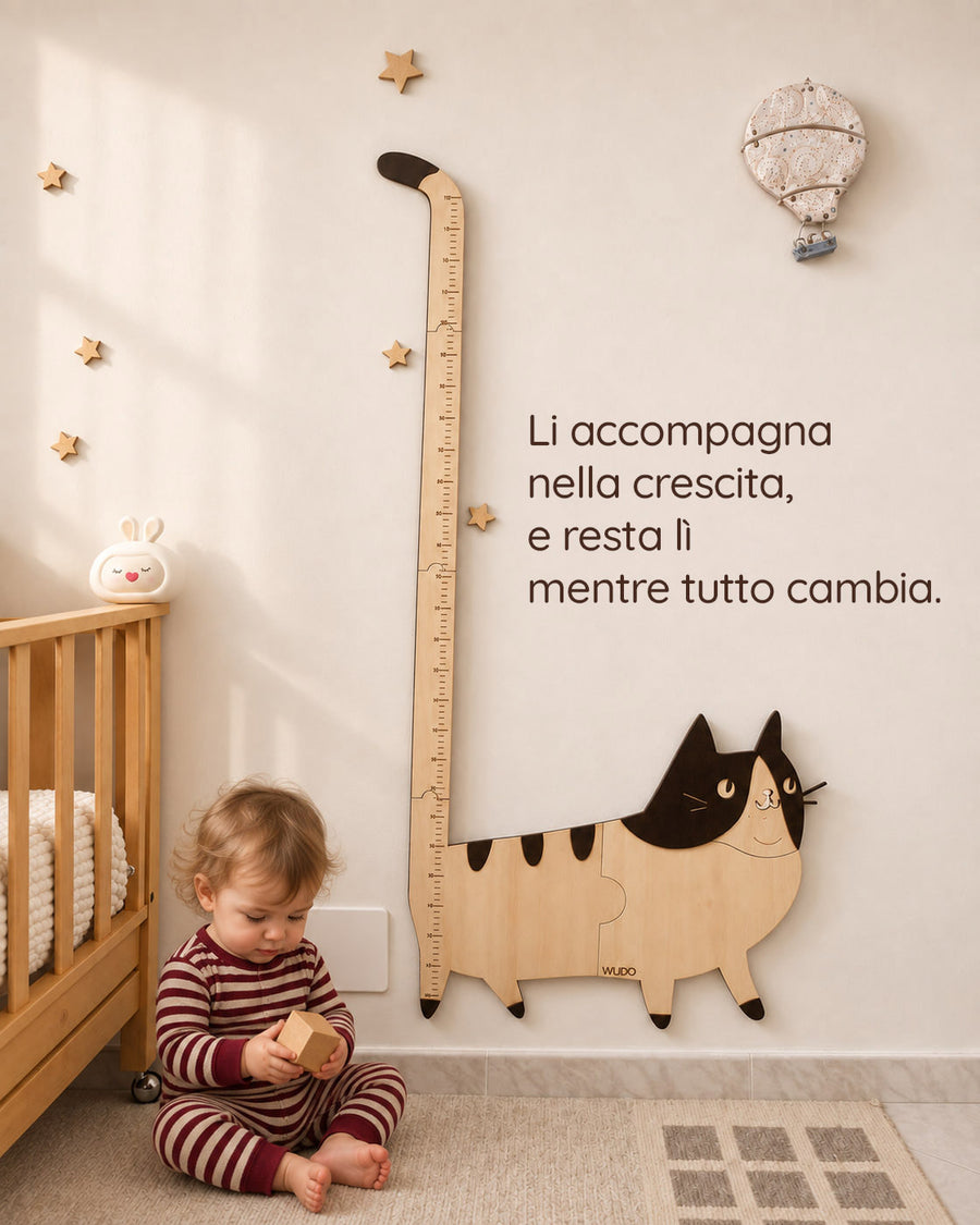 Bimbo seduto gioca con un cubo di legno accanto al metro crescita Bettina la Gattina, con la scritta: Li accompagna nella crescita, e resta lì mentre tutto cambia