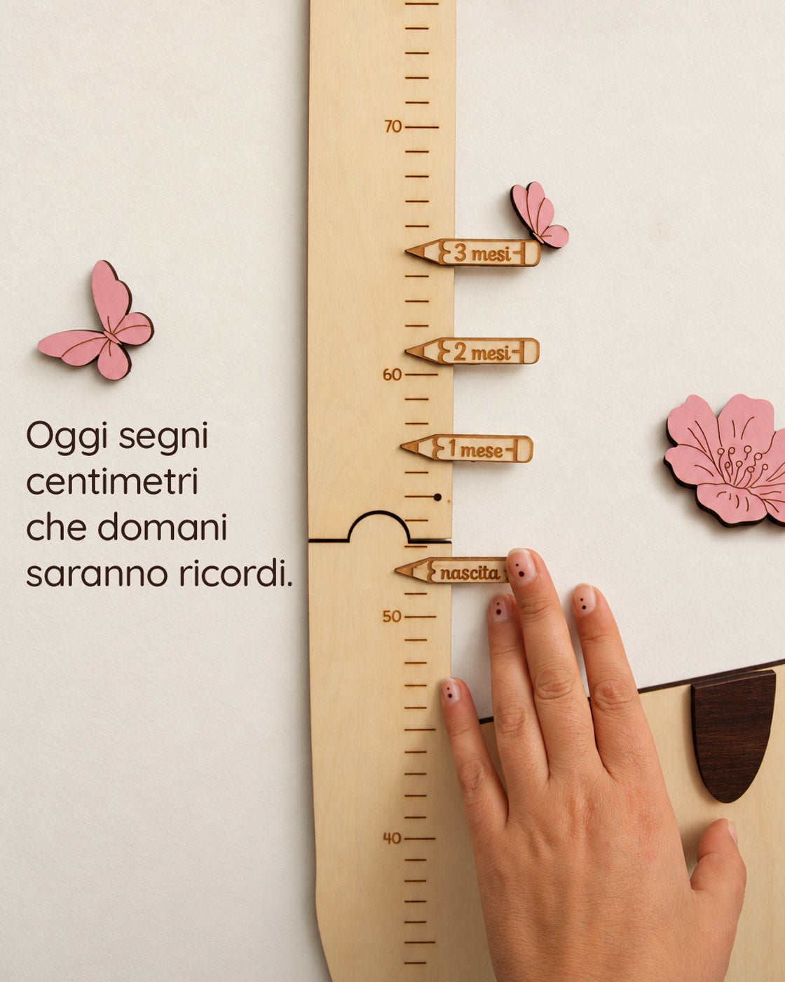 Mano accanto alle matite segna altezza nascita, 1 mese, 2 mesi e 3 mesi vendute a parte, sul metro crescita gatto, con la scritta: Oggi segni centimetri che domani saranno ricordi